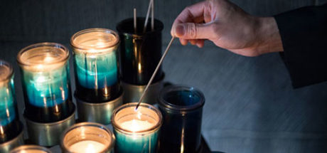 Person lighting a prayer candle