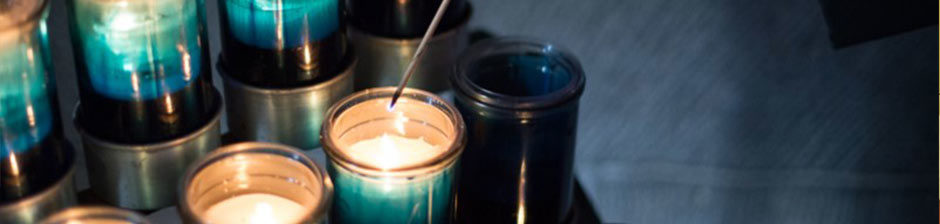 Person lighting a prayer candle