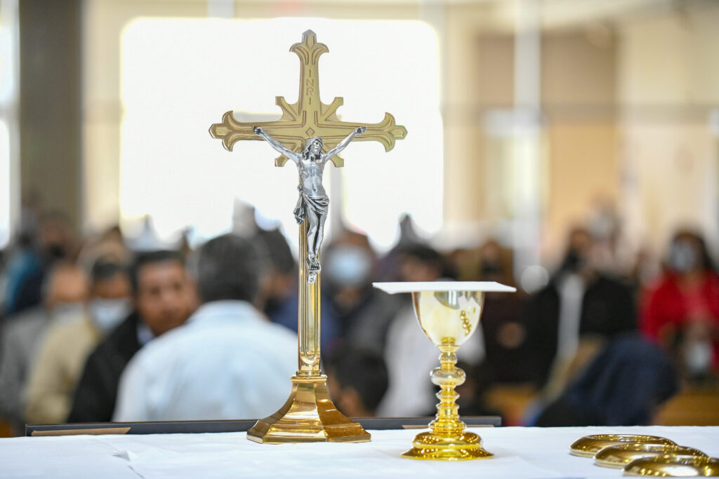 The Eucharist on the altar at St. Peter Chanel with parishioners in the background