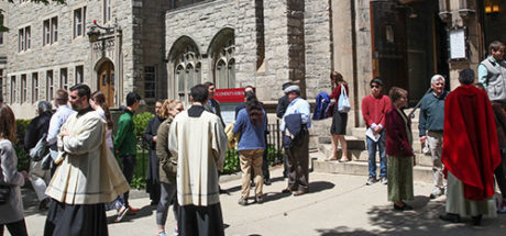 Oblates and Congregation talking outside on a nice day after Mass