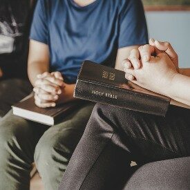 A group of people praying with bibles