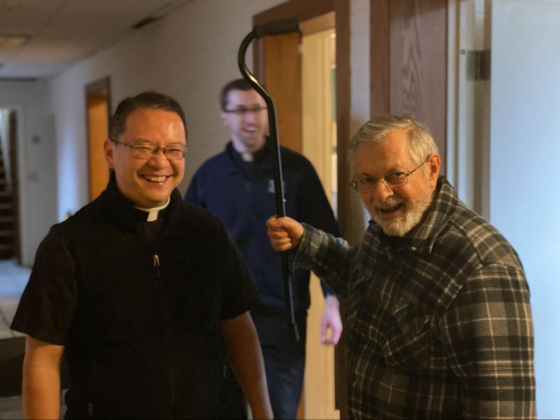 Br. Lou with fellow Oblates, shaking his cane