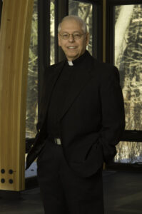 Fr. John Ferrara, OMV, smiles and stands with his hands in his pockets