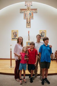 The Adamo family stands in front of the altar at St. Francis Chapel.